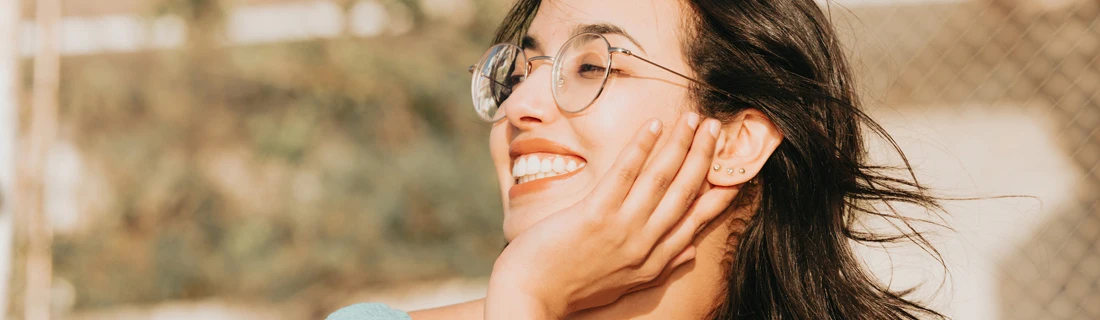 Close Up of Gorgeous Long Brown Haired Woman with Glasses Smiling with Her Hand on her Cheek